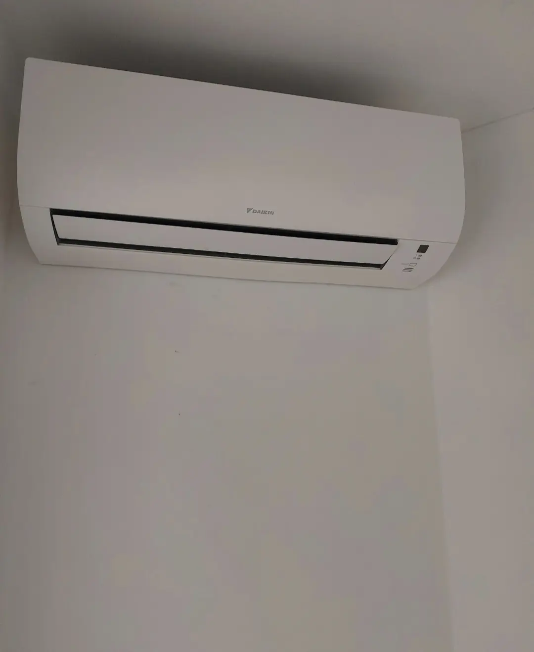 Daikin alb, montat sus, în colțul camerei